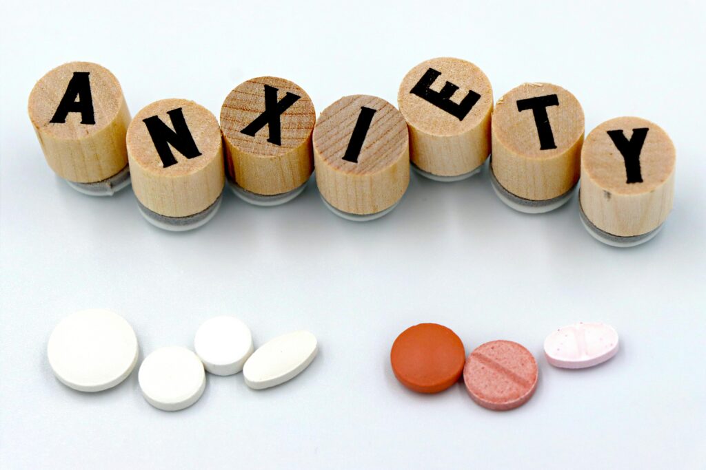 Wooden blocks spelling “Anxiety” placed above different types of medication tablets, representing anxiety disorders and medical treatment options provided through psychiatric care at Sanvedna Hospital, Aurangabad CSN.